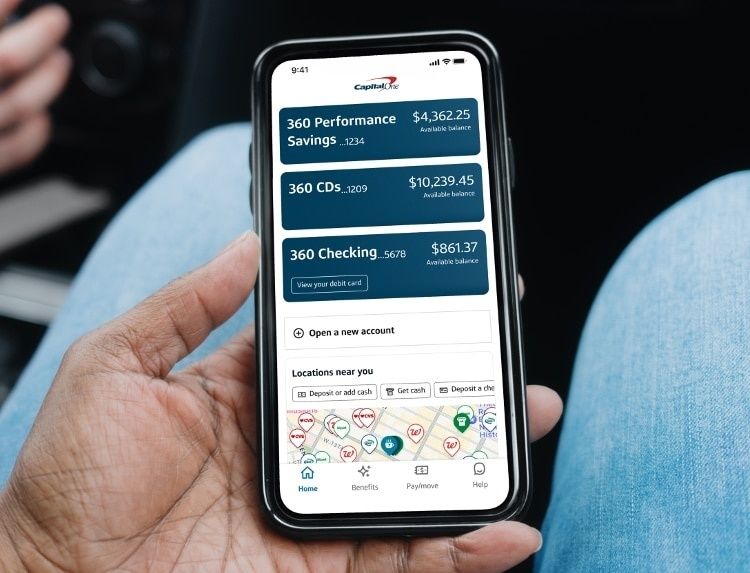 Hand håller en mobil med bankappens spar- och kontosaldon